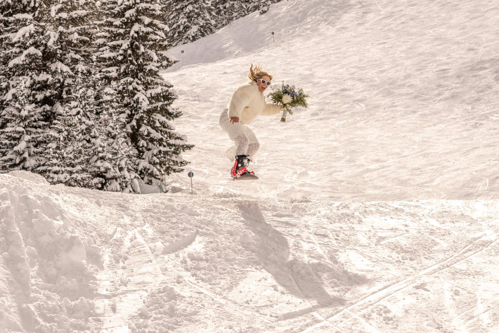 happy bride jumping on a snowboard