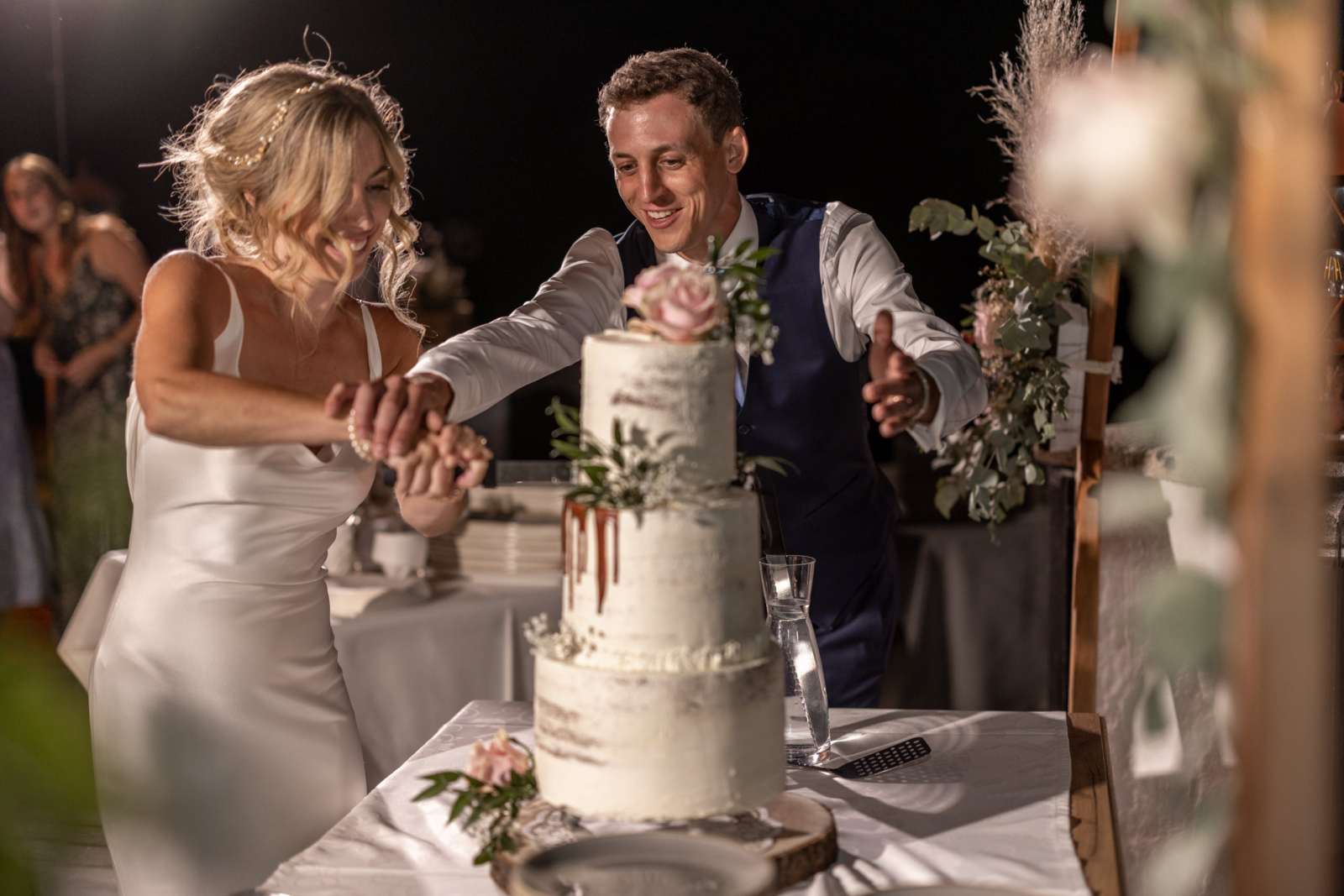 bridal couple is cutting the wedding cake